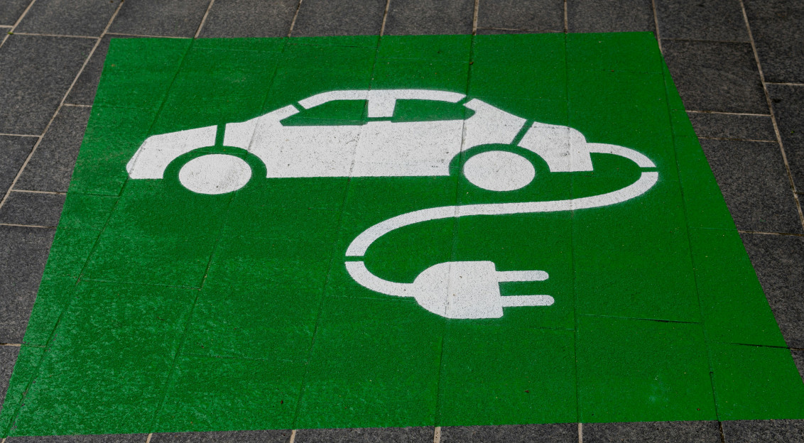 Image by Unsplash An illustrative photo of a green and white electric car sign.