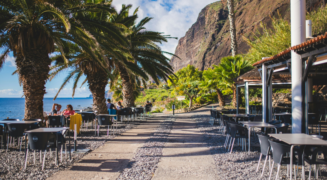 Image by Unsplash An illustrative photo of people sitting on chairs near beach.