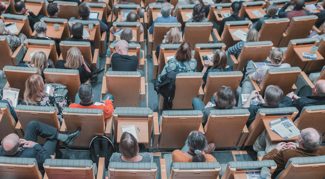 An illustrative photo of a group of people sitting in the auditorium.