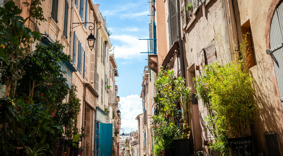Image by Unsplash An illustrative photo of cars parked on sidewalk in between buildings.