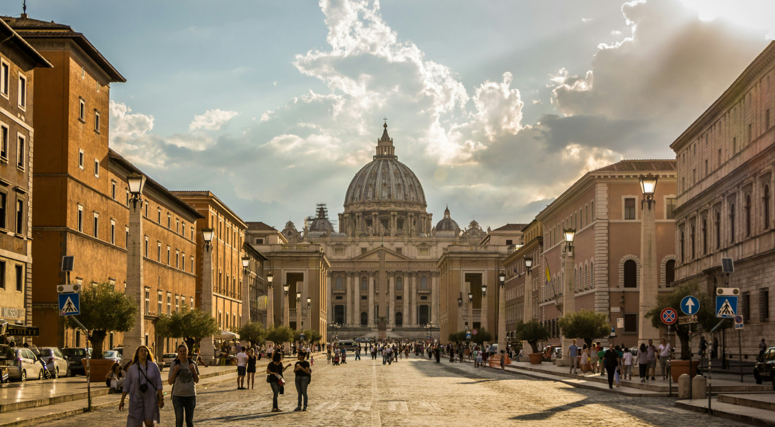 An illustrative photo of people walking on a street in Rome.
