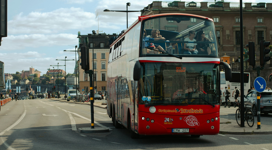 Image by Unsplash An illustrative photo of a red and white double decker bus driving down a street.