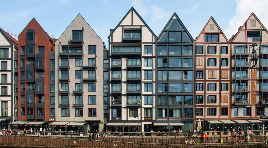 Image by Unsplash An illustrative photo of a row of buildings next to a body of water.