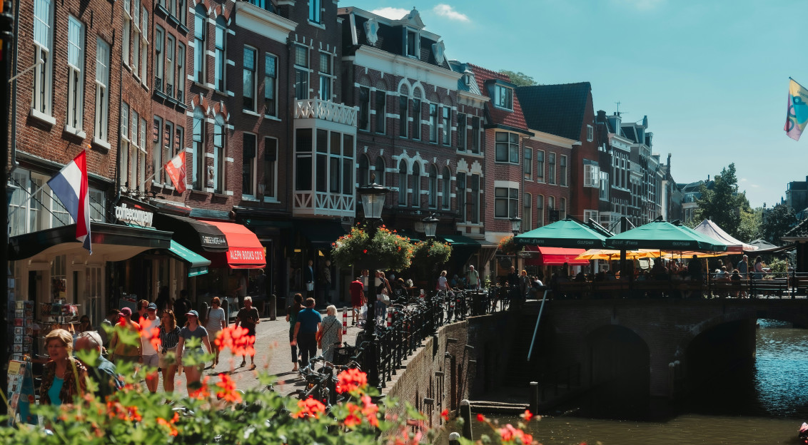 An illustrative photo of a group of people walking on a bridge over a river.