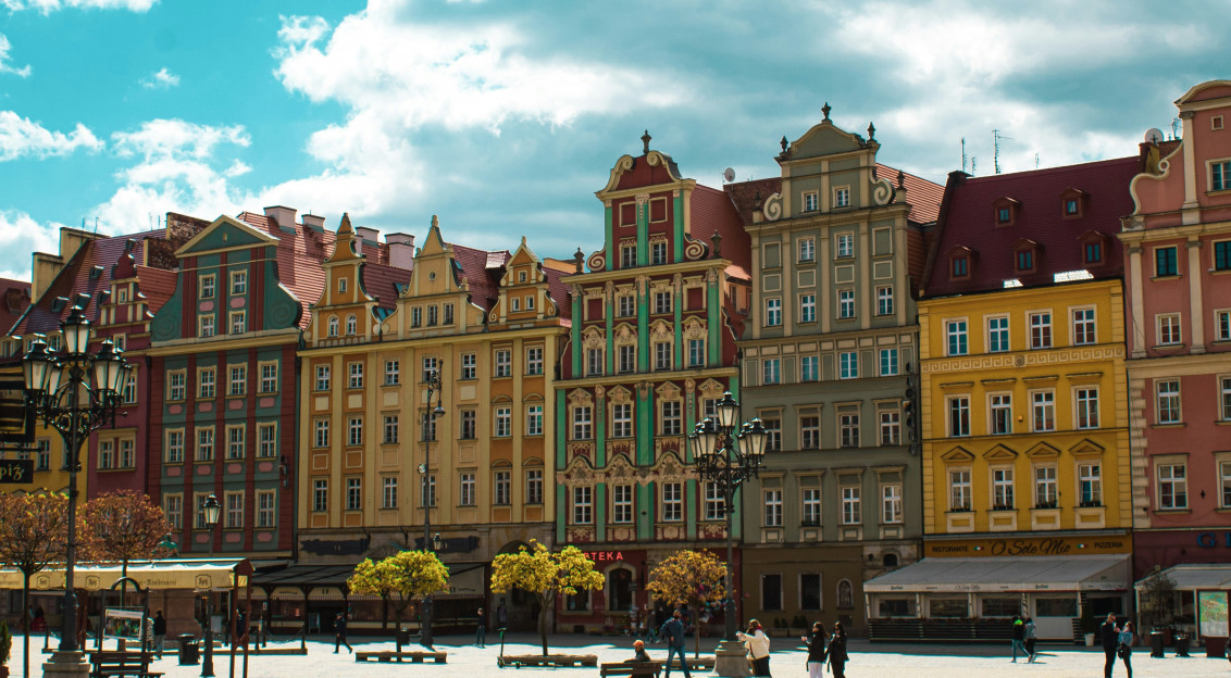 Photo by Unsplash An illustrative photo of people walking near buildings of multiple colours.