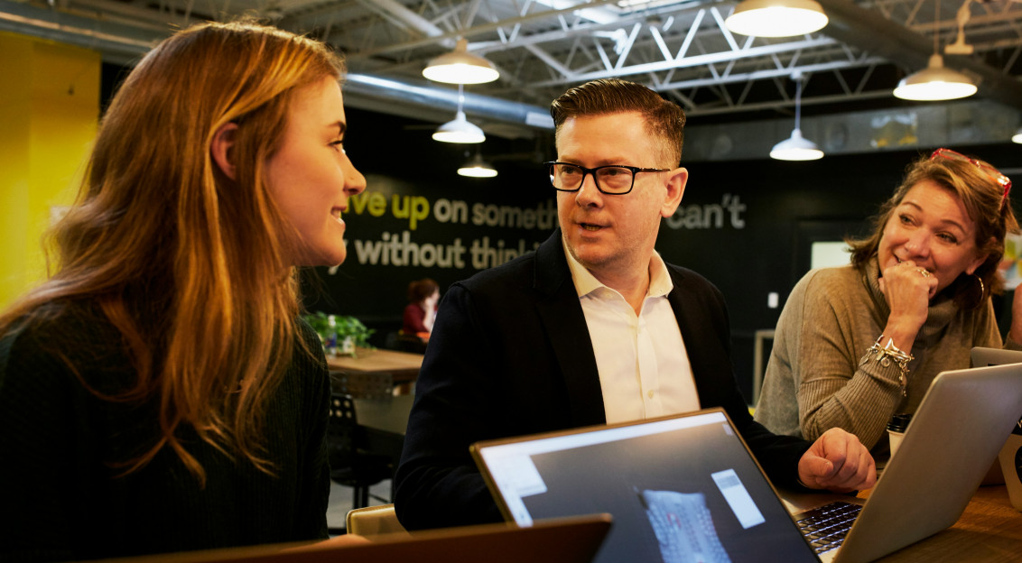 Photo by Unsplash An illustrative photo of three people talking in the office.