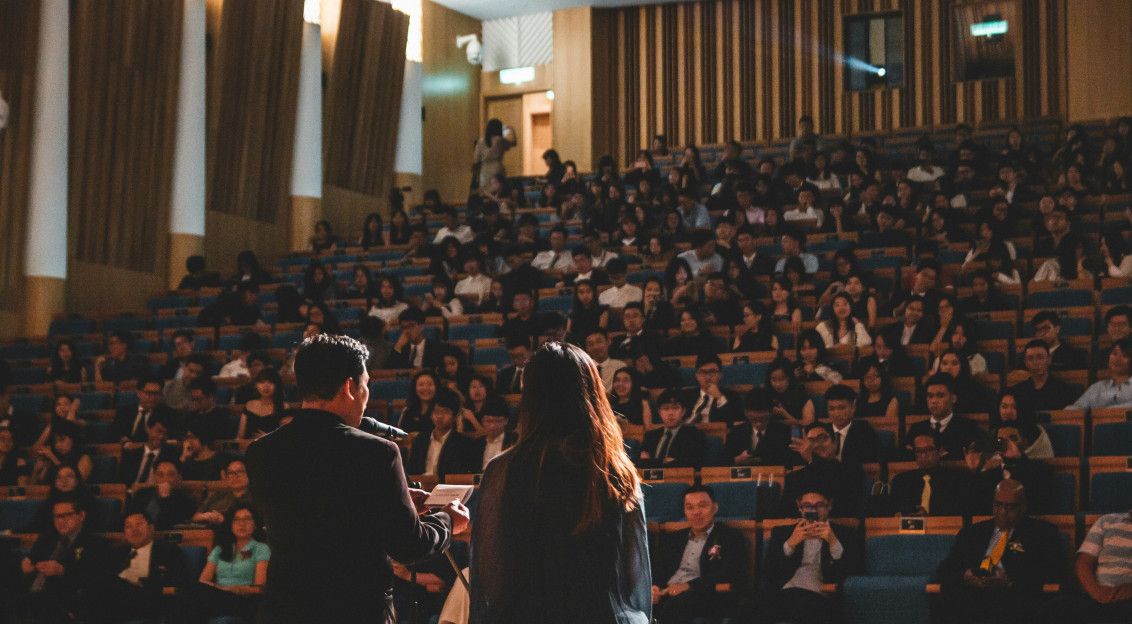 Photo by Unsplash An illustrative photo of people giving a speech in a big room.