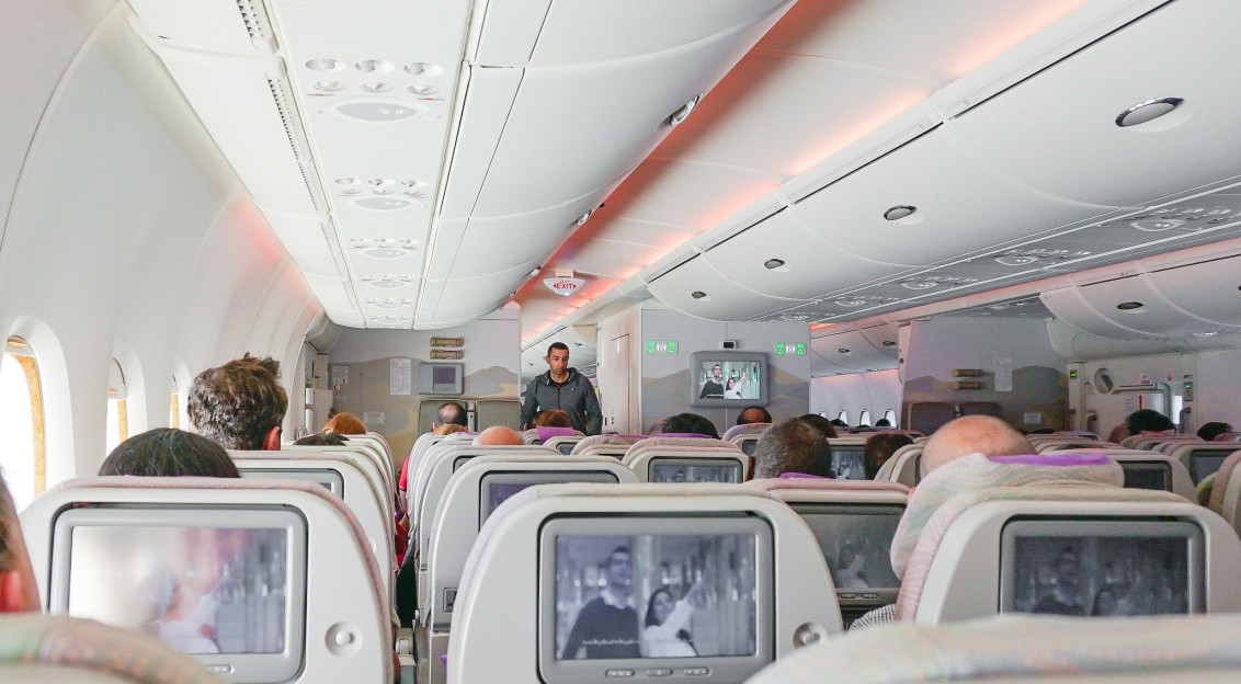Photo by Unsplash An illustrative photo of a man walking down the aisle of airplane.