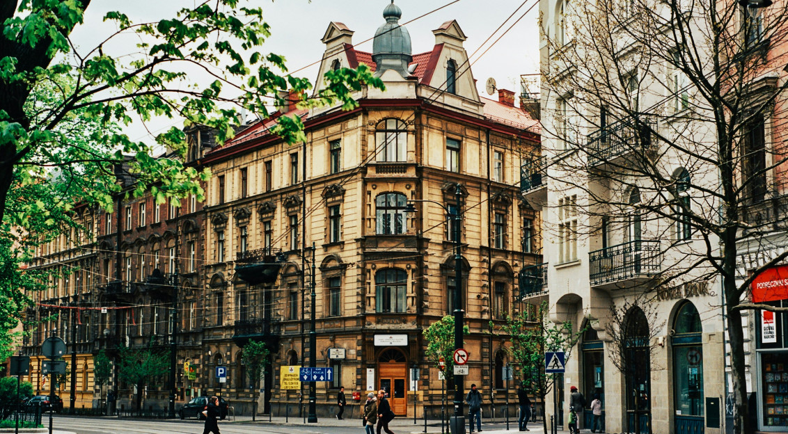 Photo by Unsplash An illustrative photo of people walking near beige buildings.