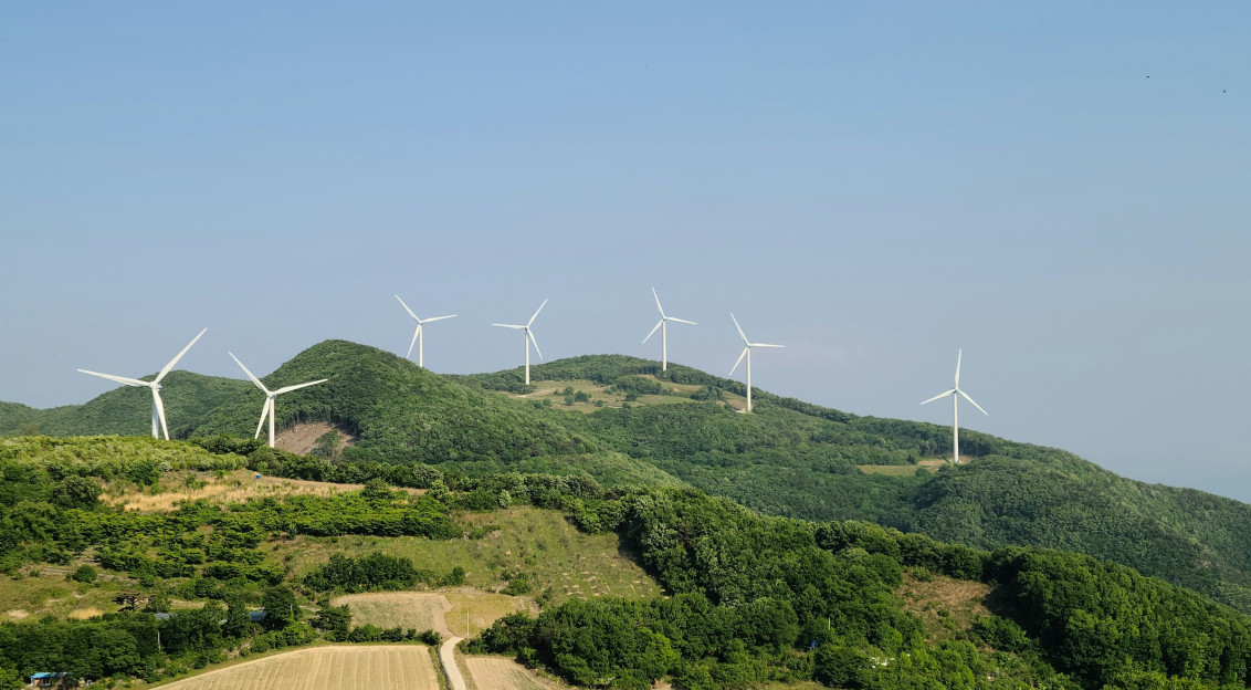 Photo by Unsplash An illustrative photo of wind turbines on a hill.