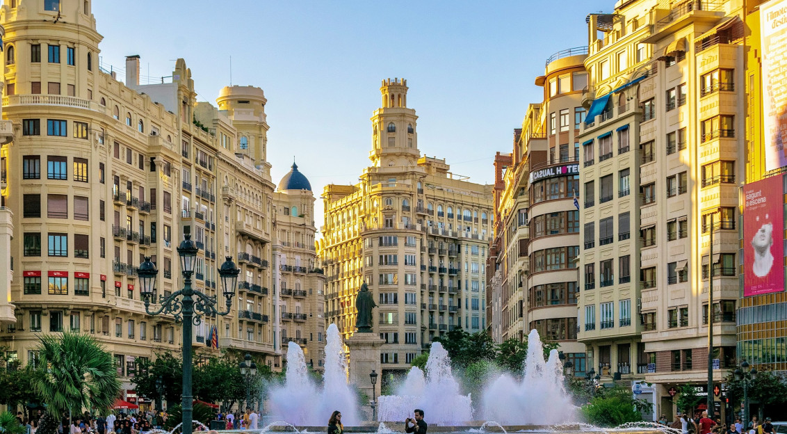 Photo by Unsplash An illustrative photo of a group of people standing around a fountain in a city.