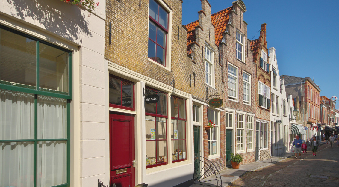 An illustrative photo of a row of buildings on a city street.