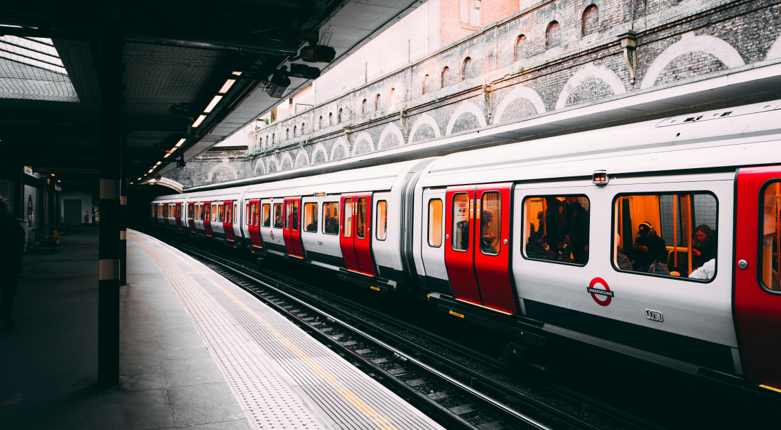 An illustrative photo of a white and red train on a station.