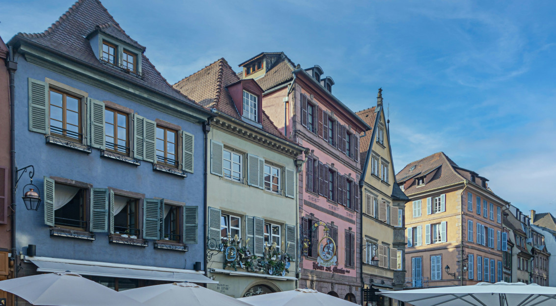 Photo by Unsplash An illustrative photo of a row of buildings with umbrellas in front of them.