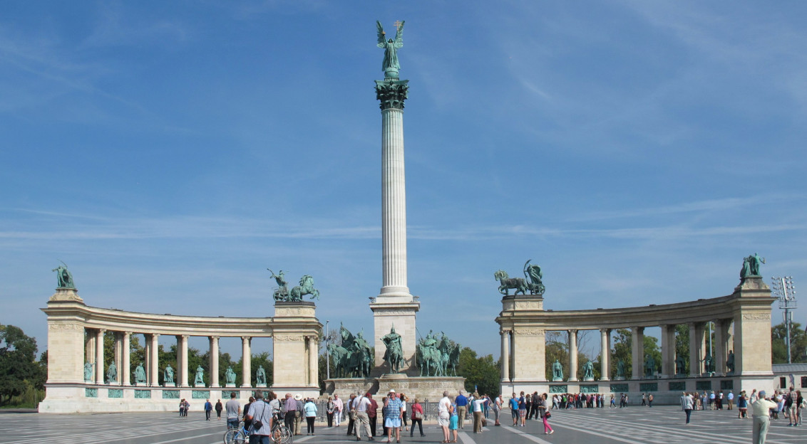 An illustrative photo of a group of people standing in front of a monument.