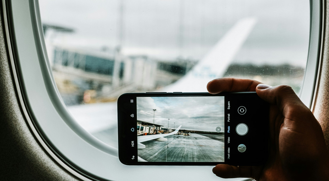 Photo by Unsplash An illustrative photo of a phone capturing plane wing.