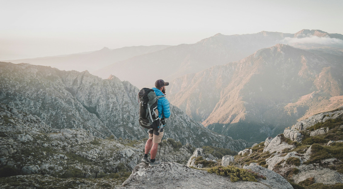 An illustrative photo of a group of a man walking on a rocky mountain.