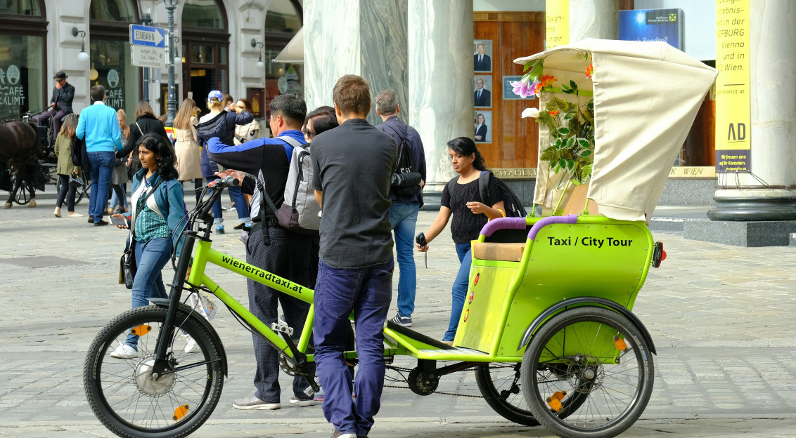 An illustrative photo of people riding a bicycle on street during daytime.