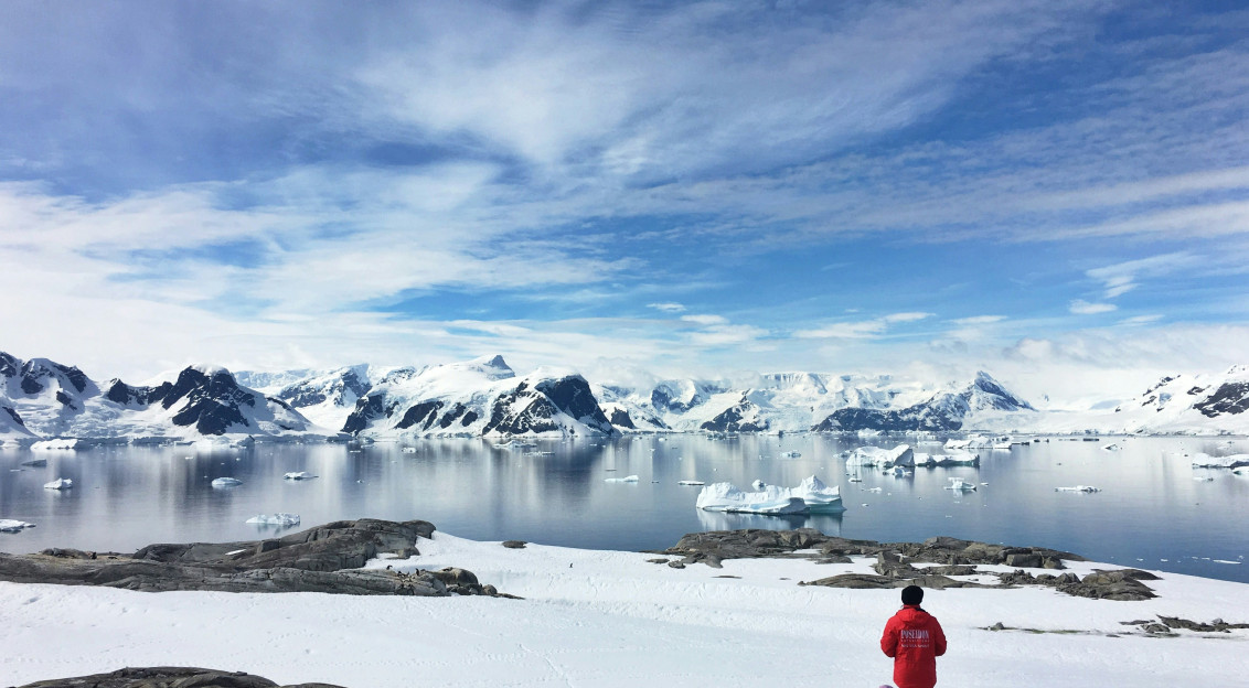An illustrative photo of two people standing on a snow-covered coast.