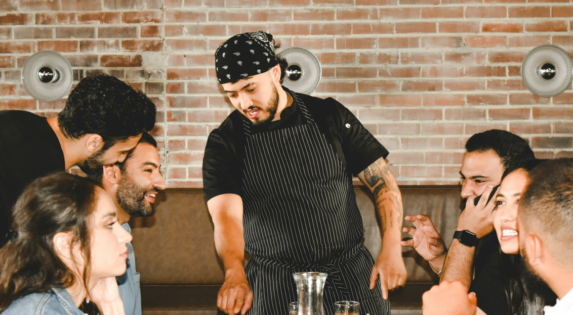 Photo by Unsplash An illustrative photo of a waiter serving people in a restaurant.