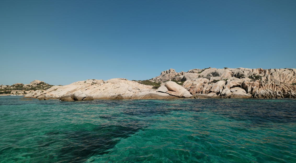 Photo by Unsplash An illustrative photo of a body of water with rocks in the background.