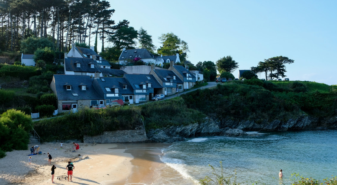 An illustrative photo of people standing a sandy beach.