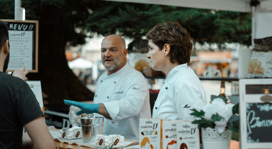 An illustrative photo of a man and a woman inside booth near man.