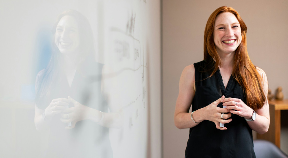 Photo by Unsplash An illustrative photo of a woman standing beside a whiteboard.