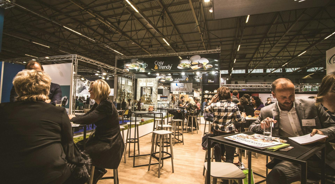People inside a cafe with tables and chairs.    