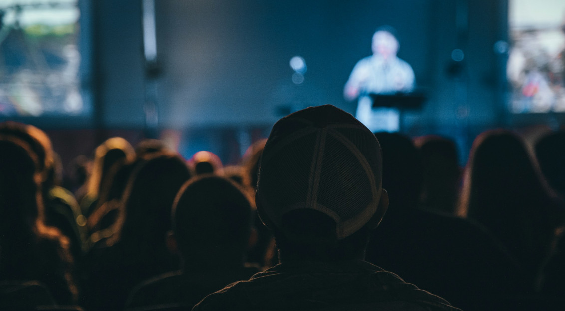 Backshot of a man looking at the stage during night time.  