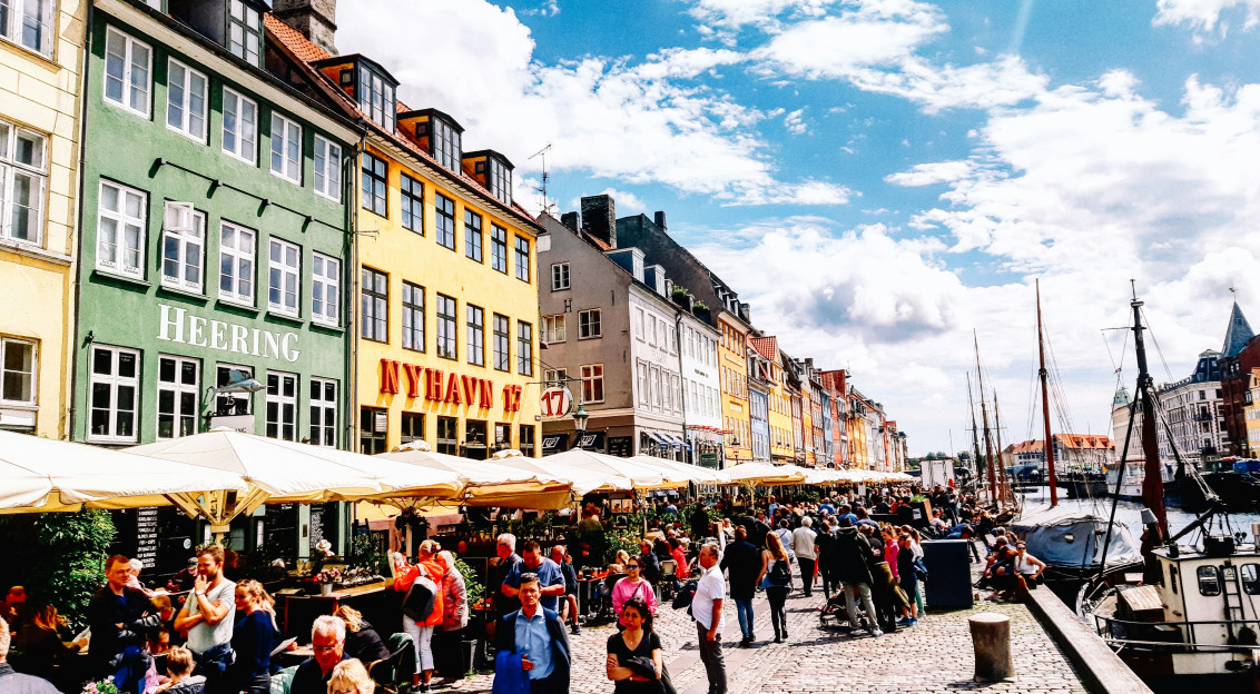 a-group-of-people-walking-down-a-street-next-to-tall-buildings