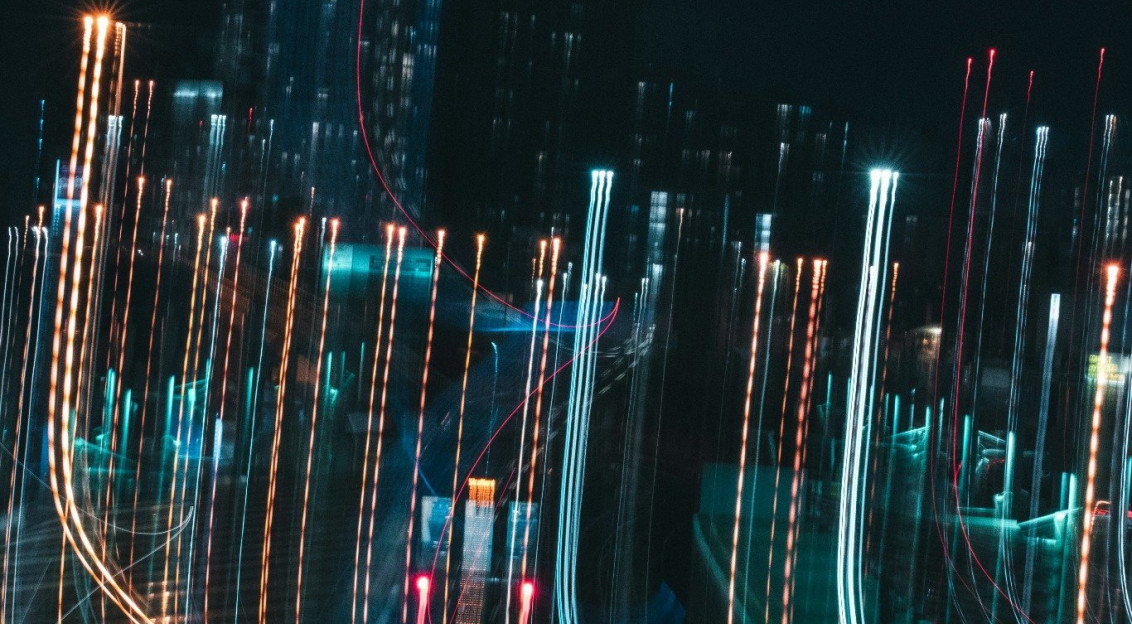 Blurred city lights at night with long exposure light trails representing digital data movement